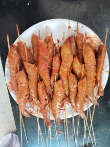 a plate of food on sticks on a table at Coco farm in Pāmban