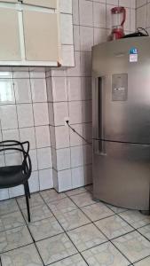 a kitchen with a stainless steel refrigerator and a chair at TECH Hostel in Sao Paulo