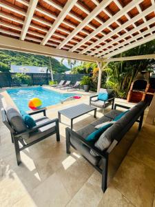 Un patio con sillas y una mesa y una piscina. en Villa dO, en Sainte-Anne 47 fotos más