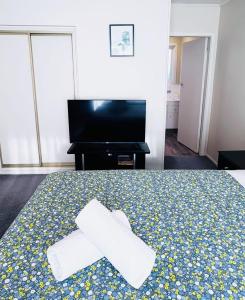 a hotel room with a bed with two towels on it at Merivale Court Superior Studio in Christchurch