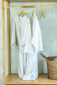 a group of white shirts hanging on a rack at Anggrek villa Ubud in Ubud +66 photos