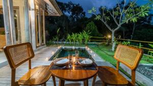a patio with a table and chairs and a pool at Anggrek villa Ubud in Ubud