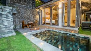 a backyard with a pool and a patio with a table at Anggrek villa Ubud in Ubud