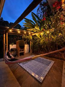 a person laying in a hammock on a patio at Mamaquilla Grupal Glamping in Jardin
