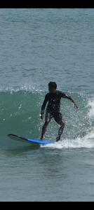 a man riding a wave on a surfboard in the ocean at Budal surfing in Legian