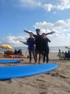a group of people standing on a beach with surfboards at Budal surfing in Legian