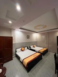 a bedroom with two beds and a cabinet at DONA hotel in Can Tho +63 photos