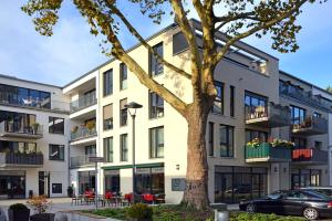an apartment building with a tree in front of it at Claudius Hotel in Bochum