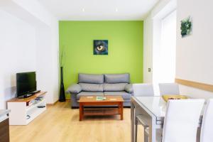 a living room with a couch and a tv at Apartamentos Tito San Agustin in Alicante