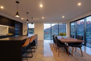 a kitchen and dining room with a wooden table and chairs at Sky Villa A in Queenstown