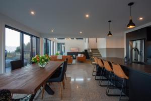 a kitchen and dining room with a wooden table and chairs at Sky Villa A in Queenstown +23 photos