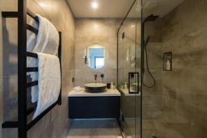 a bathroom with a sink and a glass shower at Sky Villa A in Queenstown