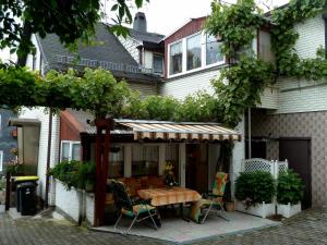 eine Terrasse mit einem Tisch und Stühlen vor einem Haus in der Unterkunft Ferienwohnung Bradsch in Ilmenau