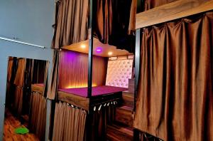 a stage with a purple seat in a room with curtains at Urbania- premium AC PG accommodation for Male in Baranagar +3 photos