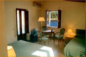 una camera da letto con un letto, un tavolo e delle sedie di illicini stabilimento balneare e albergo a Maratea
