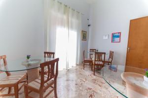 una sala da pranzo con tavolo in vetro e sedie di Corona Vacanze a Trapani