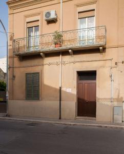 a building with a balcony and a door and a door at Corona Vacanze in Trapani