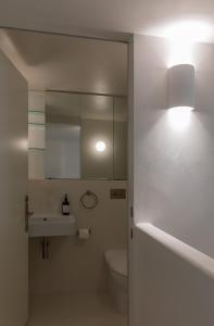 a bathroom with a toilet and a sink and a mirror at Skyline Luxury Retreat in Sydney