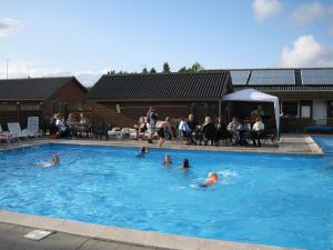 a group of people swimming in a swimming pool at Vejers Family Camping & Cottages in Vejers Strand