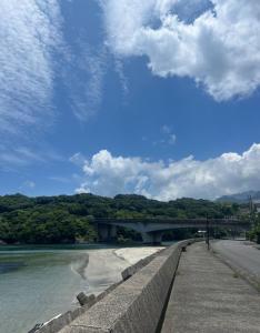 a bridge over a river with a blue sky and clouds at Anbo-ing in Yakushima
