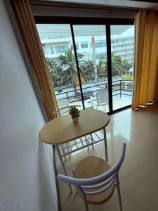 a table and a chair in a room with a window at Ging's Beach & Pool in Hua Hin