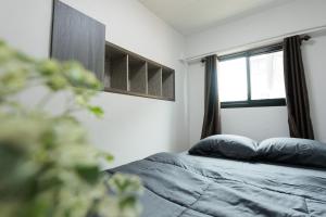 a bedroom with a bed and a window at 94Home Donmuang in Bang Khen