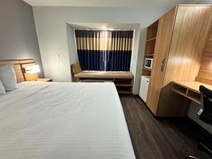 a hotel room with a large bed and a window at Microtel Inn & Suites by Wyndham Tuscaloosa East in Cottondale +19 photos