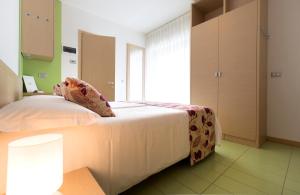 a bedroom with a bed and a large window at Hotel Trieste Mare in Lignano Sabbiadoro