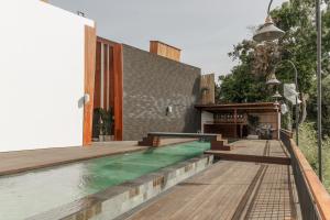 a house with a swimming pool and a wooden deck at Sunny Cuddles in Canggu +126 photos
