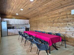 a dining room with a red table and chairs at Вили Янкови in Dobri Dyal