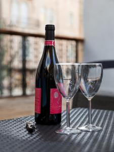 a bottle of wine and two glasses on a table at Johnny Hotel in Jerusalem