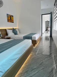 a hotel room with two beds and a glass wall at Thành Đạt Hotel in Đảo Cô Tô