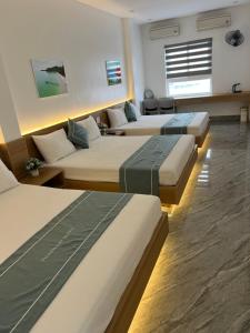 a row of beds in a room with at Thành Đạt Hotel in Đảo Cô Tô