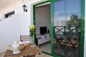 d'un salon avec une table et une porte coulissante en verre. dans l'établissement Apartamentos Dunia 211, à Puerto del Carmen