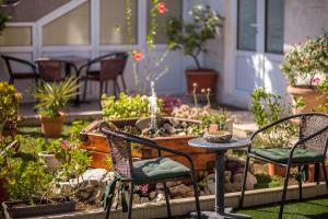 un patio con mesa y sillas y un jardín en Durakovic Apartments, en Herceg-Novi