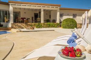 a bowl of strawberries sitting on a table in front of a house at Azul Rentals Villa Albir in Albir