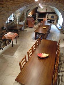 un comedor con mesas y sillas de madera en un edificio en Chambres D’hôtes Lou Jassou en Lapanouse-de-Cernon