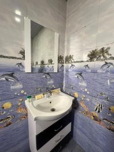 a bathroom with a sink and a mural of dolphins at Daksh The Valley Resort - Saputara in Saputara