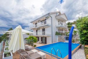 una foto di una villa con piscina di Ava Apartments a Omišalj (Castelmuschio)