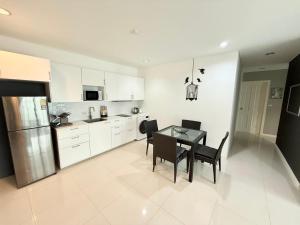 プーケットタウンにあるThe Regent Kamalaのテーブルと椅子と冷蔵庫のあるキッチン