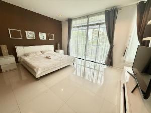 プーケットタウンにあるThe Regent Kamalaのベッドと大きな窓のある寝室 +17枚の写真