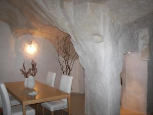 een eetkamer met een tafel en een boomwand bij Corte San Biagio,29 in Matera