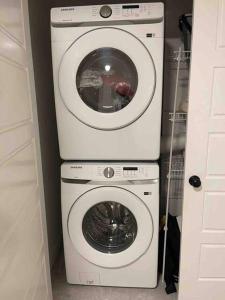a washing machine and a dryer in a room at Bedroom with TV in Upland E in Edmonton