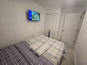 a bedroom with a bed with a tv on the wall at Bedroom with TV in Upland E in Edmonton