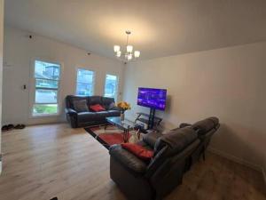 a living room with two couches and a television at Bedroom with TV in Upland E in Edmonton