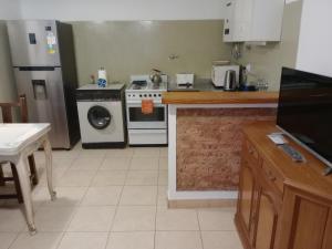 une cuisine avec une cuisinière et une machine à laver dans l'établissement Casita en el corazón de Martínez, à Martínez