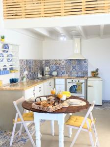 Una cocina con una mesa y sillas en una habitación. en ALEMINAS House 2, en Symi 32 fotos más