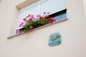 a window box with flowers on the side of a building at Apartments Hortensia in Pula