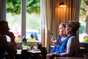 a group of women sitting at a table with wine glasses at In den Roden Leeuw van Limburg in Wittem