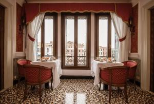 a room with a table, chairs, and a mirror at Antica Locanda Sturion Residenza d'Epoca in Venice